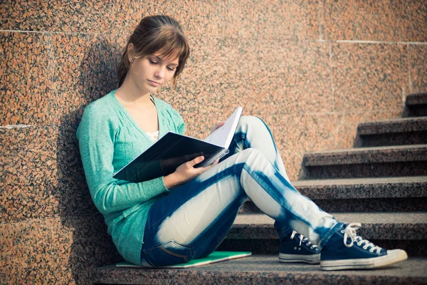 Merdivenlerde oturan ve Not okuma kız — Stok fotoğraf