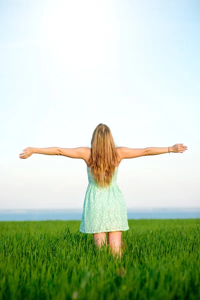 Glückliche Frau bleibt im Sonnenlicht des Sonnenuntergangs draußen — Stockfoto