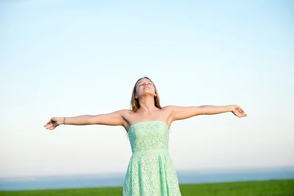 Glückliche Frau bleibt im Sonnenlicht des Sonnenuntergangs draußen — Stockfoto