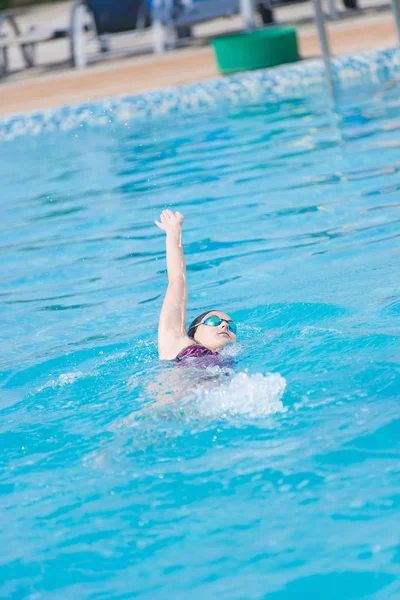 Woman in goggles swimming back crawl style — Stock Photo, Image