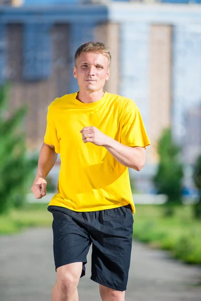 スポーティな男は都市通り公園でジョギングします。屋外フィットネス. — ストック写真