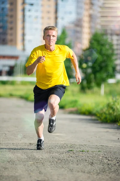 Un uomo sportivo che fa jogging nel parco cittadino. Fitness all'aperto . — Foto Stock