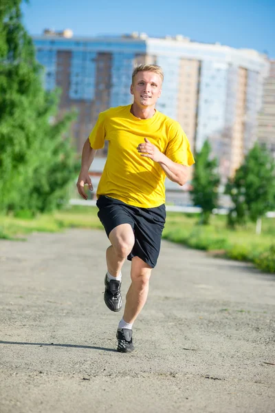 Sportovní muž, běhání v městském parku ulici. Venkovní fitness. — Stock fotografie