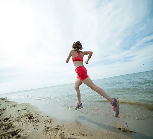 Jeune femme courant à la plage de sable ensoleillée d'été. Entraînement. Jogging — Photo
