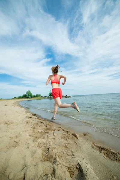Young lady running at the sunny summer sand beach. Workout.  Jog — Stock Photo, Image