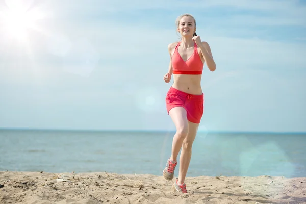 Jovencita corriendo en la soleada playa de arena de verano. Entrenamiento. Corre. —  Fotos de Stock