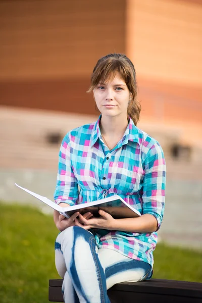 Diák lány copybook a padon. Nyári campus park. — Stock Fotó