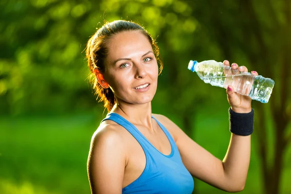 Νεαρή γυναίκα πόσιμο νερό μετά την άσκηση φυσικής κατάστασης — Φωτογραφία Αρχείου