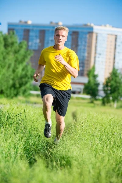 Sportovní muž, běhání v městském parku ulici. Venkovní fitness. — Stock fotografie