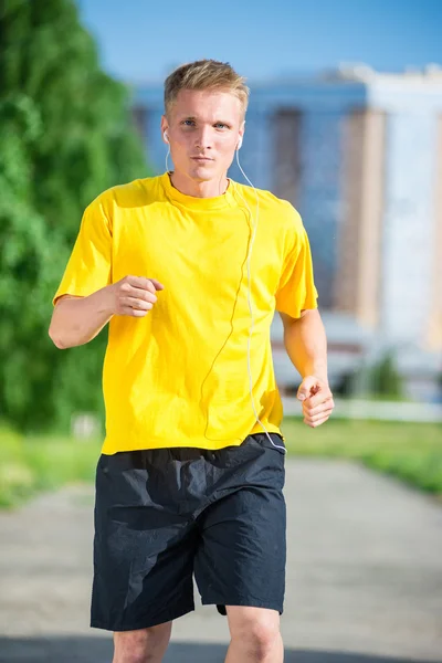 Sportig man jogga i gatan stadsparken. Utomhus fitness. — Stockfoto