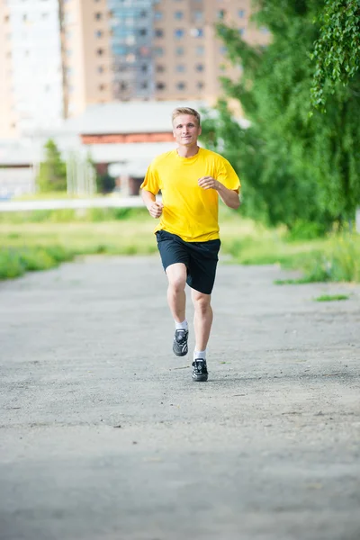 Sporty man jogging in city street park. Outdoor fitness. — Stock Photo, Image