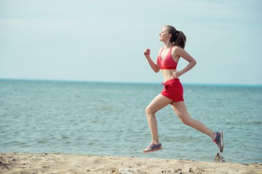 Güneşli yaz kum plajda çalışan genç bayan. Egzersiz. Jog