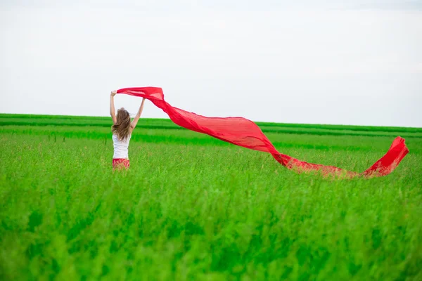 Молода леді біжить з тканиною в зеленому полі. Жінка з шарфом . — стокове фото