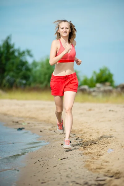 Young lady running at the sunny summer sand beach. Workout.  Jog — Stock Photo, Image