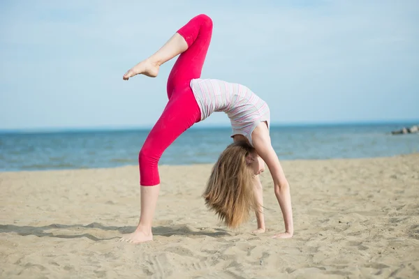 Młoda dama Praktykuje jogę. Trening w pobliżu wybrzeża Oceanu. — Zdjęcie stockowe