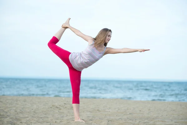 Young lady practicing yoga. Workout near ocean sea coast. — Stock Photo, Image