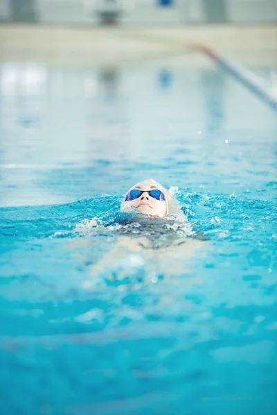 Junges Mädchen in Schutzbrille schwimmt zurück kriechen Schlaganfall Stil — Stockfoto