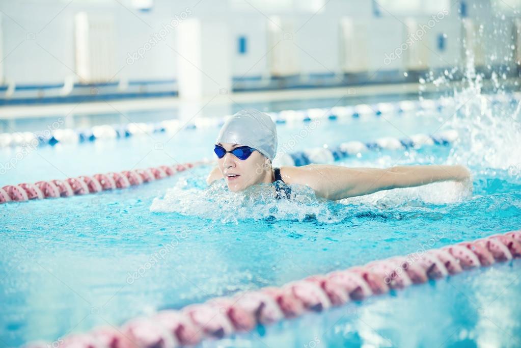 Young girl in goggles swimming butterfly stroke style