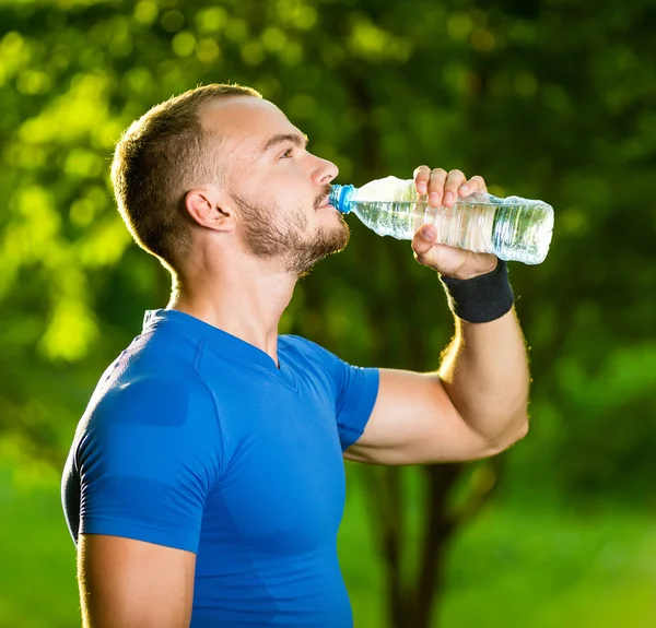 Homme mûr sportif buvant de l'eau d'une bouteille — Photo