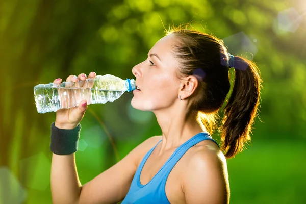 Spor sonrası su içen genç bir kadın. — Stok fotoğraf