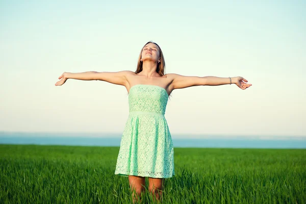 Счастье женщина оставаться на открытом воздухе под солнечным светом заката — стоковое фото