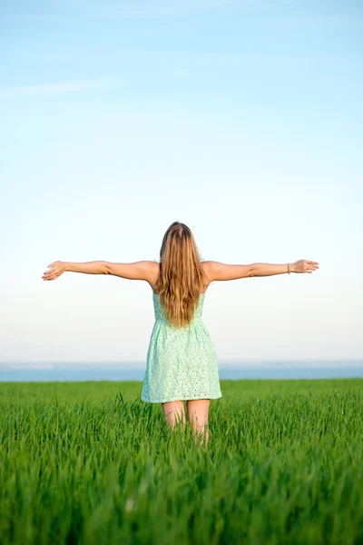 Glückliche Frau bleibt im Sonnenlicht des Sonnenuntergangs draußen — Stockfoto