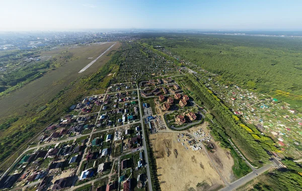 Vista aérea de la ciudad con encrucijada, caminos, casas, edificios, parques, estacionamientos, puentes — Foto de Stock