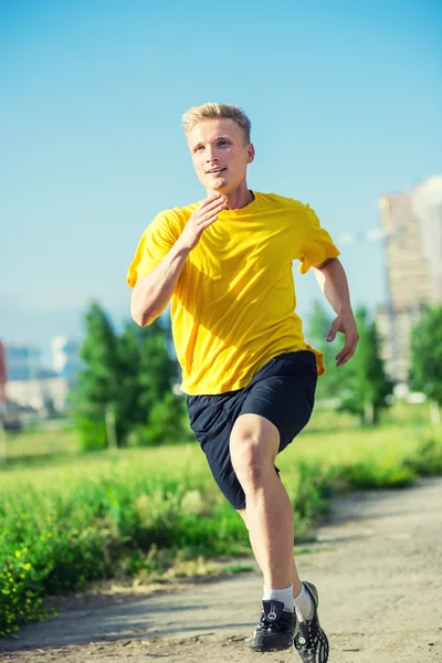 Sportovní muž, běhání v městském parku ulici. Venkovní fitness. — Stock fotografie