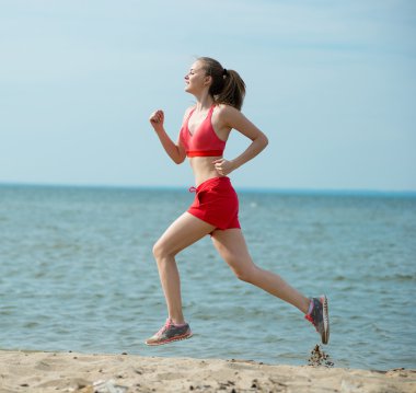 Güneşli yaz kum plajda çalışan genç bayan. Egzersiz. Jog