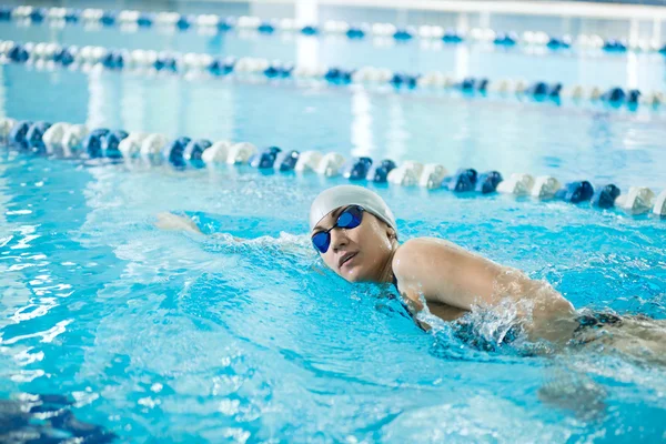 Jong meisje in bril borstcrawl streekstijl zwemmen — Stockfoto