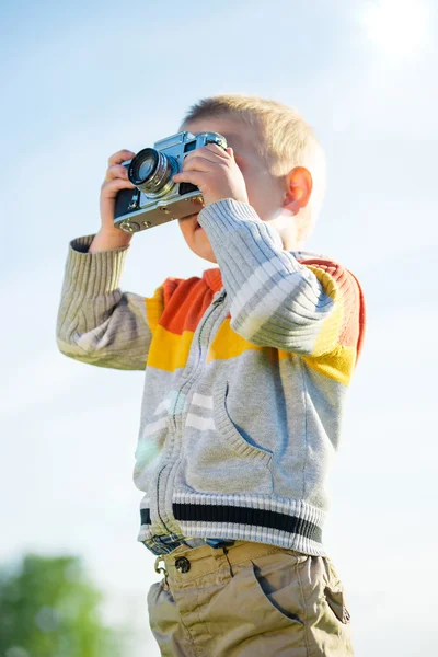 Little boy with an old camera shooting outdoor. — Stock Photo, Image