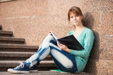 Merdivenlerde oturan ve Not okuma kız