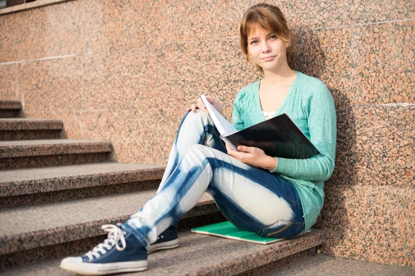 Mädchen sitzt auf Treppe und liest Notiz — Stockfoto