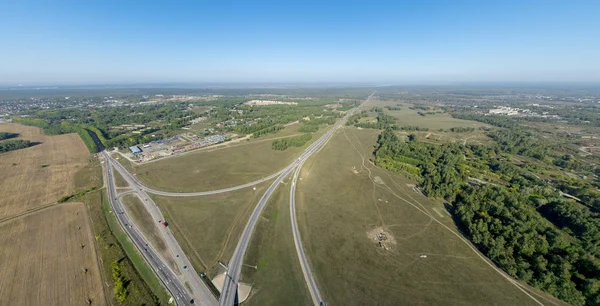 Vista aérea de la ciudad con encrucijada, caminos, casas, edificios, parques, estacionamientos, puentes —  Fotos de Stock