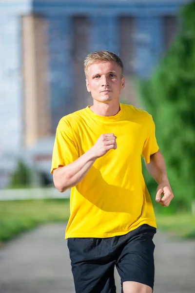 Sporty man jogging in city street park. Outdoor fitness. — Stock Photo, Image