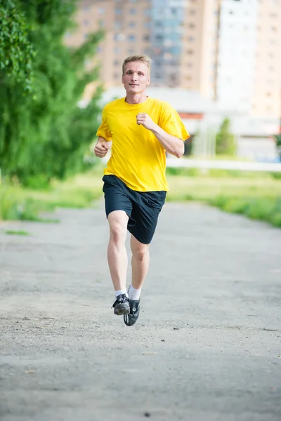 Sportovní muž, běhání v městském parku ulici. Venkovní fitness. — Stock fotografie