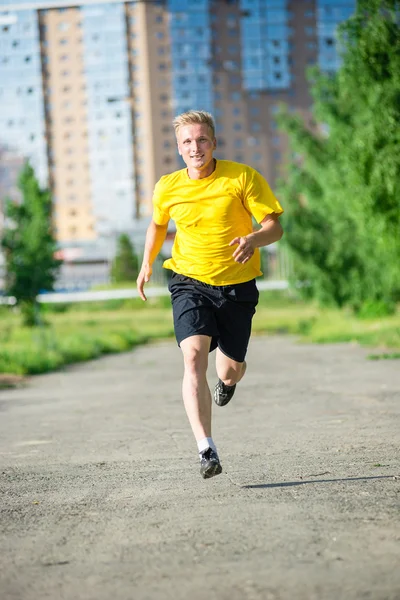 Sportieve man joggen in straat skyline van de stad. Buiten fitness. — Stockfoto