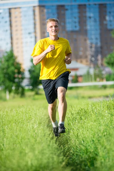 Sportlicher Mann joggt im Stadtpark. Fitness im Freien. — Stockfoto