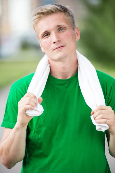 Trött man efter fitness tid och träning. Med vit handduk — Stockfoto