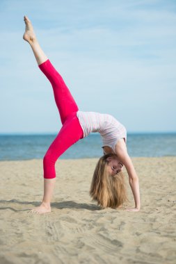 Genç Bayan pratik yoga. Okyanus deniz kıyısına yakın egzersiz.