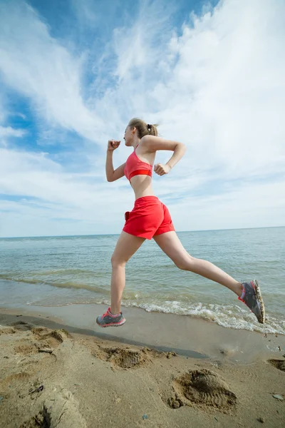 Giovane signora che corre alla soleggiata spiaggia di sabbia estiva. Allenati. Jogging — Foto Stock