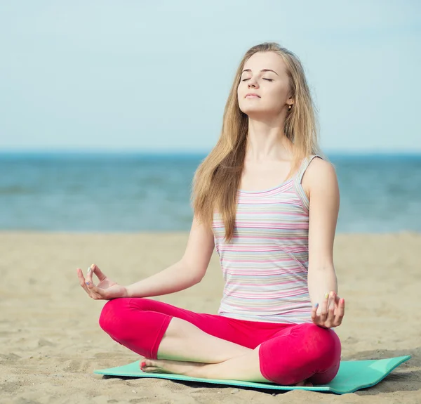 Jonge dame praktizerende yoga. Training in de buurt van de kust van de zee oceaan. — Stockfoto