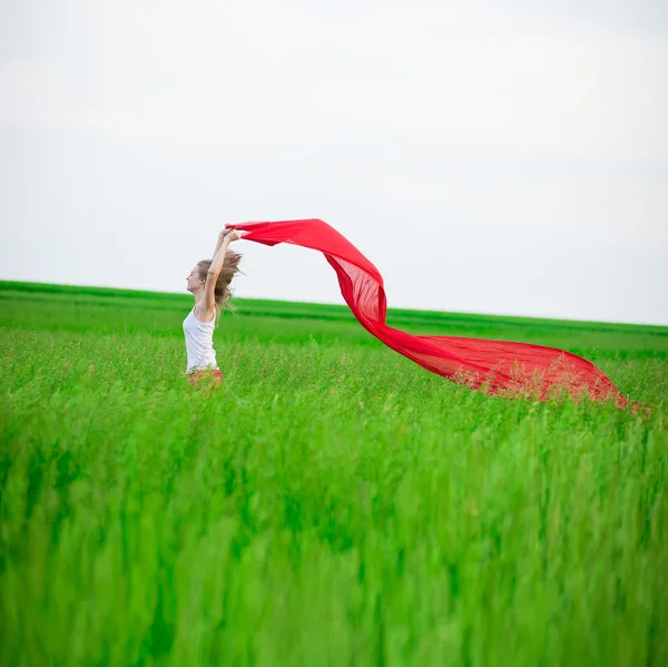 Giovane donna che corre con tessuto in campo verde. Donna con sciarpa . — Foto Stock
