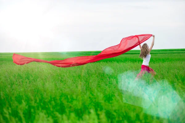 Ung dam runing med vävnader i det gröna fältet. Kvinna med halsduk. — Stockfoto