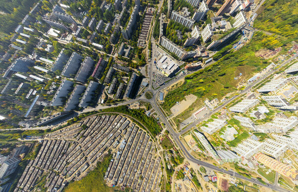 Aerial city view with crossroads and roads, houses, buildings, parks and parking lots, bridges. Copter shot. Panoramic image