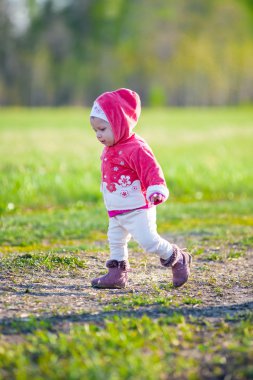 Çayırda yürüyüş ve güneşe bakarak mutlu küçük kız