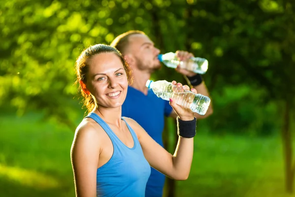 Férfi és nő ivóvíz palack fitness sport edzés után — Stock Fotó