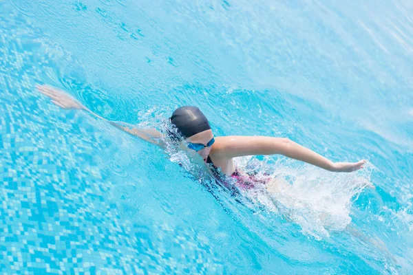 Woman in goggles swimming front crawl style — Stock Photo, Image