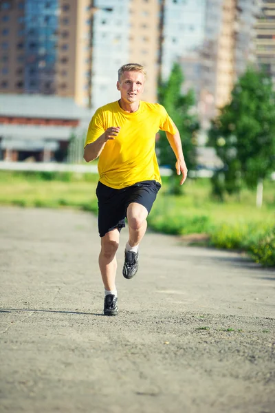 Sporty man jogging in city street park. Outdoor fitness. — Stock Photo, Image