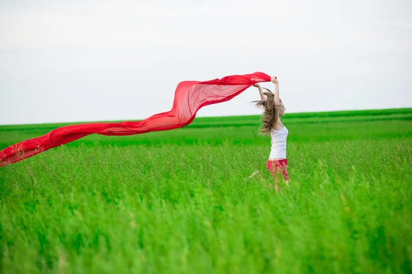 Wanita muda berlari dengan jaringan di lapangan hijau. Wanita dengan syal . — Stok Foto